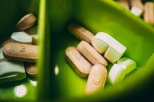 Wat je moet weten over medicatie en voeding Voeding speelt een cruciale rol in de effectiviteit van medicatie. Wat je eet kan de opname, metabolisme en uitscheiding van medicijnen beïnvloeden. Dit betekent dat bepaalde voedingsmiddelen de werking van je medicatie kunnen versterken of verzwakken. Het is belangrijk om te begrijpen dat de interactie tussen voeding en medicatie niet altijd voor de hand liggend is. Soms kan een schijnbaar onschuldig voedingsmiddel een aanzienlijke impact hebben op hoe goed je medicatie werkt. Bijvoorbeeld, vetrijke maaltijden kunnen de absorptie van sommige medicijnen vertragen, terwijl andere medicijnen beter worden opgenomen in combinatie met voedsel. Dit maakt het essentieel om niet alleen aandacht te besteden aan de medicatie zelf, maar ook aan wat je eet. Het is een goed idee om met je arts of apotheker te overleggen over hoe jouw dieet je medicatie kan beïnvloeden. Voedingsmiddelen die de werking van medicatie kunnen beïnvloeden Er zijn verschillende voedingsmiddelen die bekend staan om hun invloed op medicatie. Grapefruit is een van de meest besproken voorbeelden. Het bevat stoffen die enzymen in de lever kunnen remmen, wat leidt tot een verhoogde concentratie van bepaalde medicijnen in het bloed. Dit kan potentieel gevaarlijk zijn, vooral bij medicijnen die al een smalle therapeutische index hebben. Daarnaast kunnen zuivelproducten de opname van sommige antibiotica verminderen. Calcium in melk en yoghurt bindt zich aan deze medicijnen, waardoor ze minder effectief worden. Ook vezelrijke voedingsmiddelen kunnen de absorptie van bepaalde medicijnen beïnvloeden door de snelheid van de spijsvertering te veranderen. Het is dus belangrijk om je bewust te zijn van deze interacties en je dieet hierop aan te passen. Hoe voeding medicatie kan versterken of verminderen Voeding kan niet alleen de effectiviteit van medicatie verminderen, maar ook versterken. Sommige voedingsmiddelen kunnen de werking van medicijnen verbeteren door hun absorptie te bevorderen of door synergetische effecten te creëren. Bijvoorbeeld, vitamine C kan de opname van ijzersupplementen verbeteren, wat nuttig kan zijn voor mensen met bloedarmoede. Aan de andere kant kunnen bepaalde diëten, zoals een hoogvetdieet, de effectiviteit van medicijnen die bedoeld zijn om cholesterol te verlagen, verminderen. Dit komt doordat vetten de manier waarop het lichaam deze medicijnen verwerkt kunnen beïnvloeden. Het is dus belangrijk om niet alleen te kijken naar wat je eet, maar ook naar hoe deze voedingsmiddelen samenwerken met je medicatie. Tips voor het innemen van medicatie in combinatie met voeding Een goede manier om ervoor te zorgen dat je medicatie optimaal werkt, is door enkele eenvoudige richtlijnen te volgen bij het innemen ervan. Ten eerste is het belangrijk om altijd de bijsluiter van je medicatie te lezen. Hierin staan vaak specifieke instructies over het innemen met of zonder voedsel. Daarnaast kan het nuttig zijn om een routine te ontwikkelen voor het innemen van je medicijnen. Probeer ze op dezelfde tijdstippen in te nemen, zodat je beter kunt onthouden of je ze met voedsel moet innemen of niet. Als je twijfelt over een bepaald voedingsmiddel en de interactie met je medicatie, aarzel dan niet om dit met je arts of apotheker te bespreken. Veelvoorkomende voedingsinteracties met medicatie Er zijn verschillende veelvoorkomende voedingsinteracties die je moet kennen. Zoals eerder genoemd, kan grapefruit de werking van veel medicijnen beïnvloeden, waaronder statines en sommige bloeddrukmedicatie. Ook groene bladgroenten kunnen invloed hebben op bloedverdunners zoals warfarine, omdat ze rijk zijn aan vitamine K, wat de werking van deze medicijnen kan verminderen. Daarnaast kunnen cafeïne en alcohol ook invloed hebben op hoe goed je medicatie werkt. Cafeïne kan bijvoorbeeld de effecten van sommige antidepressiva versterken, terwijl alcohol de bijwerkingen van veel medicijnen kan verergeren. Het is dus verstandig om voorzichtig te zijn met deze stoffen als je medicijnen gebruikt. Het belang van het lezen van bijsluiters en het raadplegen van een arts of apotheker Het lezen van bijsluiters is essentieel voor iedereen die medicatie gebruikt. Deze documenten bevatten belangrijke informatie over mogelijke interacties met voedsel en andere medicijnen. Het is niet ongebruikelijk dat mensen deze informatie negeren, maar dit kan leiden tot ongewenste bijwerkingen of een verminderde effectiviteit van de behandeling. Als je vragen hebt over je medicatie of twijfels hebt over hoe voeding invloed kan hebben op je behandeling, is het altijd een goed idee om contact op te nemen met je arts of apotheker. Zij kunnen je voorzien van gepersonaliseerd advies en ervoor zorgen dat je medicatie zo effectief mogelijk is. Specifieke dieetadviezen bij bepaalde medicatie Sommige medicijnen vereisen specifieke dieetadviezen om hun effectiviteit te maximaliseren. Bijvoorbeeld, mensen die statines gebruiken om cholesterol te verlagen, wordt vaak aangeraden om hun inname van verzadigde vetten te beperken en meer vezels te consumeren. Dit kan helpen om het cholesterolniveau verder te verlagen en de effectiviteit van de medicatie te ondersteunen. Bij andere medicijnen, zoals sommige antidepressiva, kan het nuttig zijn om een dieet rijk aan omega-3-vetzuren te volgen. Deze vetzuren zijn aangetoond dat ze een positieve invloed hebben op de geestelijke gezondheid en kunnen helpen bij het verbeteren van de effectiviteit van deze medicijnen. Het is belangrijk om deze dieetadviezen serieus te nemen en ze in overleg met een zorgverlener toe te passen. Het belang van een gebalanceerd dieet bij het gebruik van medicatie Een gebalanceerd dieet is cruciaal voor iedereen, maar vooral voor mensen die medicatie gebruiken. Een gezond dieet ondersteunt niet alleen de algehele gezondheid, maar kan ook helpen bij het optimaliseren van de werking van medicijnen. Voedingstekorten kunnen leiden tot verminderde effectiviteit van medicatie en zelfs tot extra bijwerkingen. Het is belangrijk om voldoende variëteit in je dieet aan te brengen, met voldoende groenten, fruit, volle granen en eiwitten. Dit zorgt ervoor dat je lichaam alle benodigde voedingsstoffen binnenkrijgt om optimaal te functioneren en medicijnen effectief te verwerken. Vergeet niet dat goede voeding hand in hand gaat met goede gezondheid, vooral als je afhankelijk bent van medicatie voor jouw welzijn. FAQs 1. Wat is de relatie tussen medicatie en voeding? Medicatie en voeding kunnen een wisselwerking hebben, wat invloed kan hebben op de werking van de medicatie. Sommige voedingsmiddelen kunnen de opname van medicatie beïnvloeden, terwijl andere voedingsmiddelen de werking van medicatie kunnen versterken of verminderen. 2. Welke voedingsmiddelen kunnen de werking van medicatie beïnvloeden? Voedingsmiddelen zoals grapefruit, kruisbloemige groenten (zoals broccoli en spruitjes), en zuivelproducten kunnen de werking van bepaalde medicatie beïnvloeden. Het is belangrijk om hier rekening mee te houden bij het innemen van medicatie. 3. Zijn er voedingsmiddelen die de opname van medicatie kunnen verminderen? Ja, bepaalde voedingsmiddelen kunnen de opname van medicatie verminderen, zoals vezelrijke voeding, cafeïne en bepaalde kruiden. Dit kan ervoor zorgen dat de medicatie minder effectief is. 4. Zijn er algemene richtlijnen voor het innemen van medicatie in combinatie met voeding? Het is belangrijk om de bijsluiter van de medicatie te raadplegen voor specifieke richtlijnen met betrekking tot voeding. Over het algemeen is het verstandig om medicatie in te nemen met voldoende water, tenzij anders aangegeven door een zorgverlener. 5. Wat moet ik doen als ik vragen heb over medicatie en voeding? Als je vragen hebt over de wisselwerking tussen medicatie en voeding, is het raadzaam om contact op te nemen met een apotheker of huisarts. Zij kunnen advies op maat geven en eventuele zorgen wegnemen.